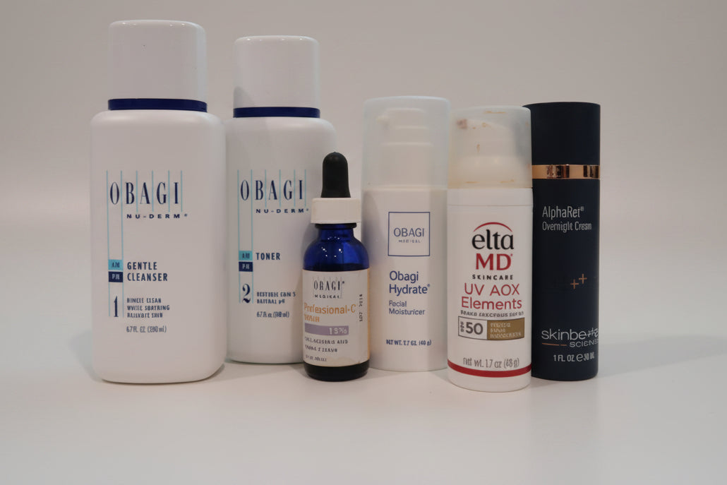 Collection of skincare products including Obagi and Elta MD on a white surface.
